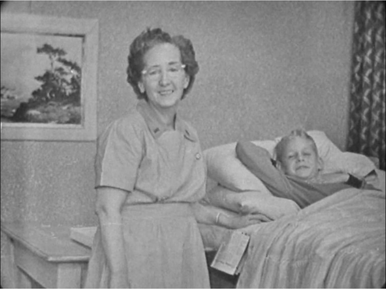 A nurse tends a child in bed
